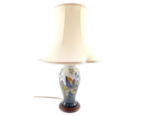 A Moorcroft Pottery table lamp decorated in the Blackberry Bramble pattern, of baluster form, raised on a wooden base, impres