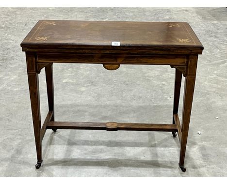 An Edward VII rosewood and inlaid card table, the inlet fold-over top on square tapered legs. 34" wide.
