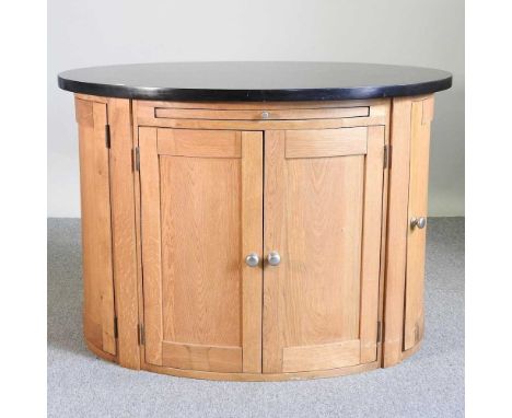 A modern light oak oval kitchen island, with a black marble top122w x 92d x 87h cm