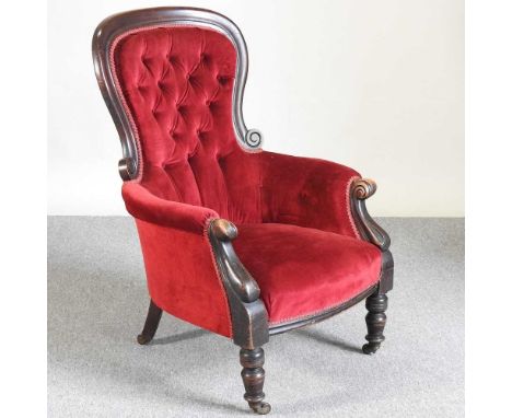 A Victorian red upholstered button back armchair, on turned legs
