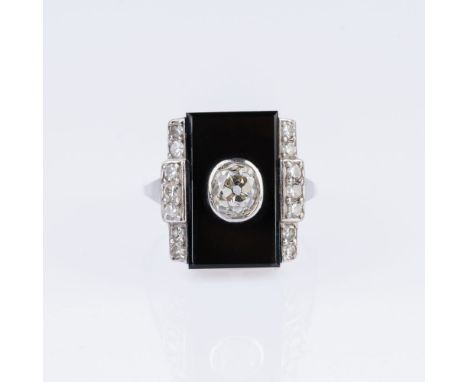 Art-déco Onyx-Diamant-Ring. Um 1920. 18 und 14 kt. WG. Der Diam. im antiken Kissenschliff ca. 0,45 - 0,50 ct. Getönt(M).vvs. 