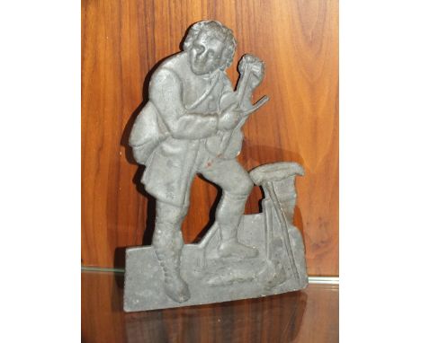 A VINTAGE CAST METAL PLAQUE IN THE FORM OF A MAN WITH A VIOLIN