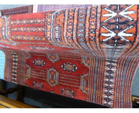 A Tekke red and orange tone ladder medallion rug, 68.5 x 49 inches.