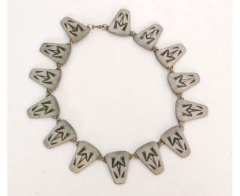 A 1950s Danish pewter necklace designed as fourteen panels each decorated with an Aztec Frog motif, united by hoop links with