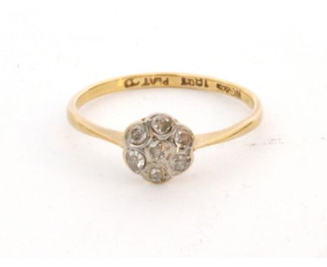 An early 20th Century 18ct diamond daisy cluster ring, seven old cut stones to knife edged shoulders, ring size P.