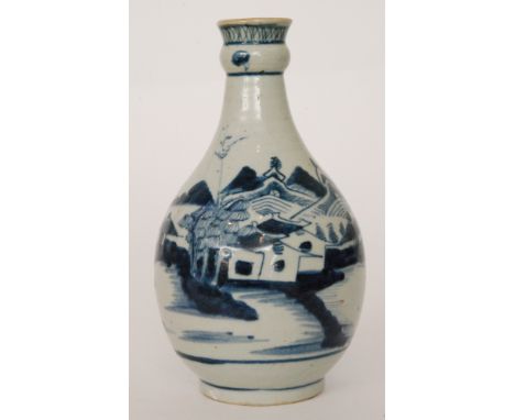 A late 19th to early 20th Century bottle vase with a knop ring to the neck decorated in blue and white with a landscape scene