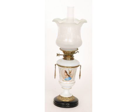 A Victorian brass oil lamp and shade with transfer panel of a girl wearing a headress on gilt and white opaque urn base, heig