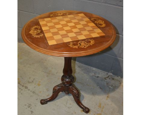 A Victorian mahogany occasional games table of circular form, with chequer board inlaid top and with acanthus detail, on a tu