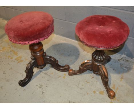 Two Victorian revolving piano stools each upholstered in crimson and pink plush, on tripod legs. (2)