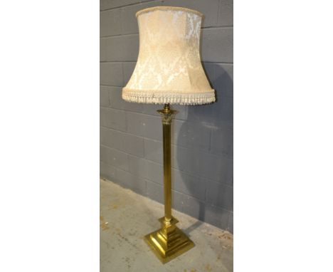 A 20th Century brass standard lamp with Corinthian column over a stepped base, complete with shade, height 128cm