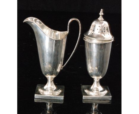 A hallmarked silver strawberry set comprising of helmet shaped cream jug on square pedestal base with matching sugar sifter, 