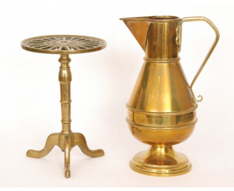An early 20th Century Ecclesiastical brass jug with angular spout and tapering body, height 44cm, and a brass tripod trivet. 