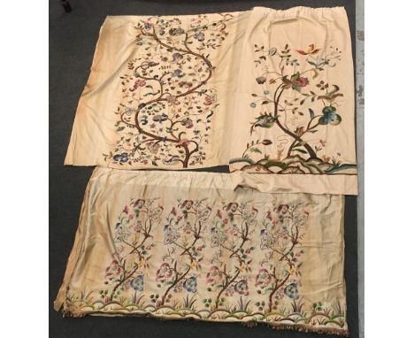 A pair of 1930s Arts and Crafts style stumpwork type woolwork curtains embroidered with fruiting trees above resting deer and