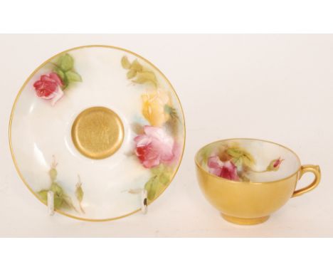 A Royal Worcester cabinet cup and saucer decorated with hand painted roses to the interior of the cup and the rim of the sauc