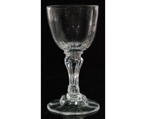 An 18th Century champagne glass circa 1755, panel moulded cup form bowl above an eight sided pedestal stem between collars, r