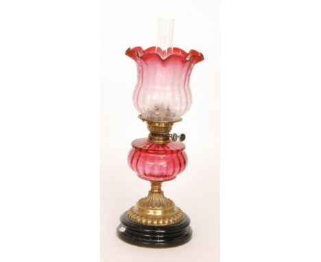 A Victorian style oil lamp and etched shade, ruby reservoir and brass basalt circular base, height 49cm.