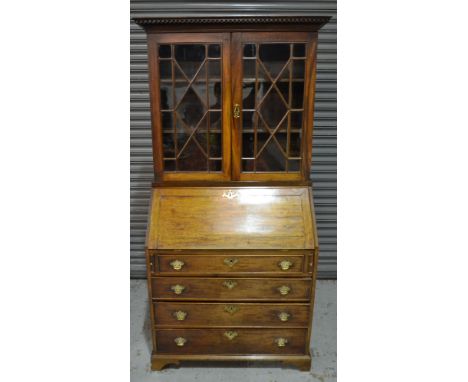 A Georgian mahogany bureau bookcase, with a dentil cornice above astragal glazed double doors, the fall front enclosing a fit