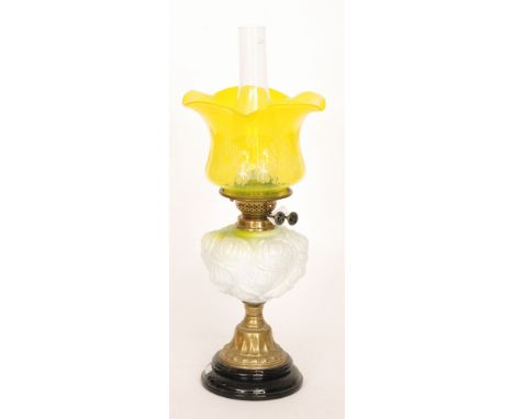A Victorian oil lamp and yellow etched shade with moulded and embossed reservoir on black glazed base, height 58cm.