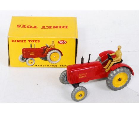 A Dinky Toys No. 300 Massey Harris tractor comprising of red body with brown driver and yellow hubs, in the original all-card