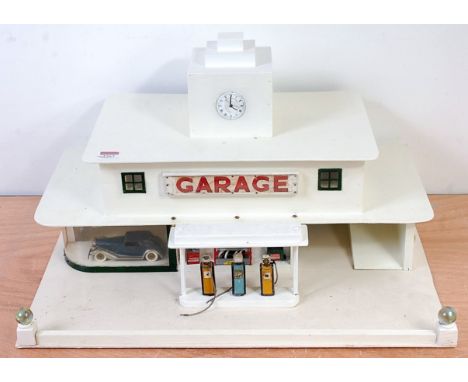 A commercially built Art Deco garage comprising of wooden white building with enamelled clock face and garage sign to front, 