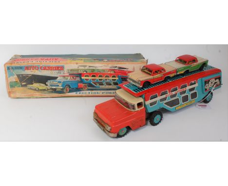 A TN Nomura of Japan tin plate and friction drive model of an auto carrier, comprising red and cream tractor unit with blue, 