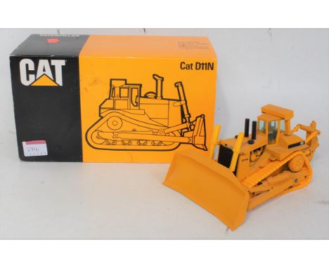 A Conrad No. 2852 1/50 scale model of a Caterpillar D11N tract dozer with scraper, housed in the original polystyrene packagi