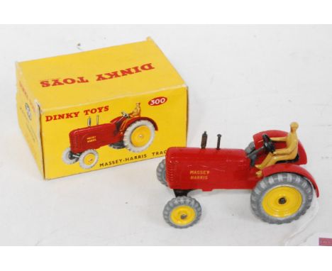 A Dinky Toys No. 300 Massey Harris tractor comprising of red body with yellow hubs and brown driver, in the original picture 