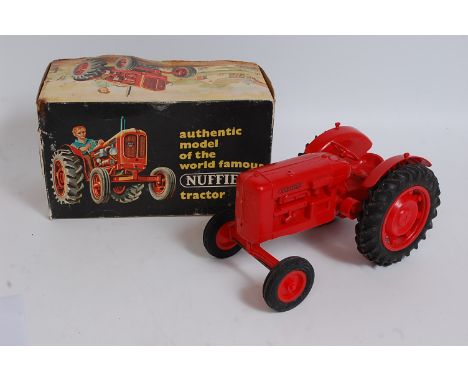 A Pippin Toys large scale plastic model of a Nuffield tractor, comprising of red body with matching red plastic hubs, missing