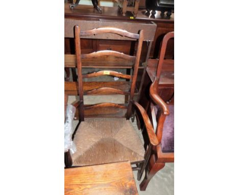 A ladder back elbow chair with rush seat
