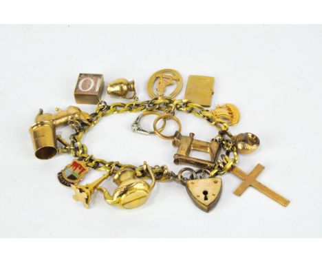 A vintage rolled gold charm bracelet, with heart locket, on which are numerous 9ct gold charms, including a tankard, cross an