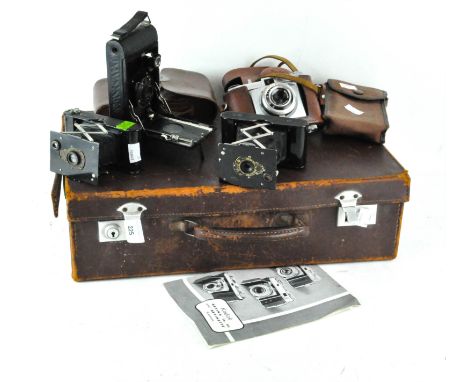 A vintage leather briefcase containing four cameras, including an Eastman Kodak co vest pocket camera no 44568, another simil