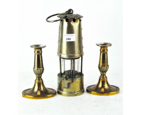 An early/mid 20th century "The Protector" miners lamp, Manchester height 26cm, together with two brass candlesticks