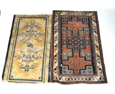 Two rugs, one of Chinese design with blue and white scroll pattern on a yellow ground,150cm x 95cm, the other with a blue and