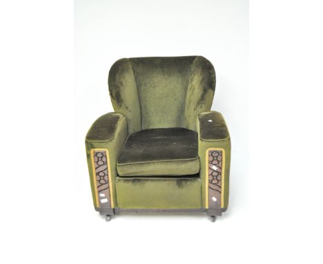 A vintage green upholstered armchair, with carved detailing to the front, raised upon castors, 85cm high