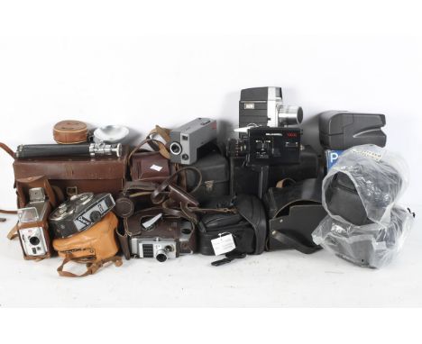 A collection of vintage cameras and camera bags, including a Bell &amp; Howell film camera, a Kodak Brownie 8mm film camera, 