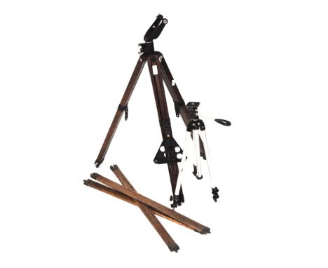 A collection of tripods, including vintage early 20th century wooden examples and a metal example.