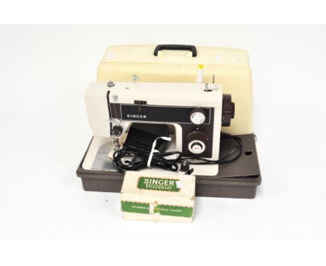 A vintage Singer electric sewing machine, in plastic case, with foot pedal