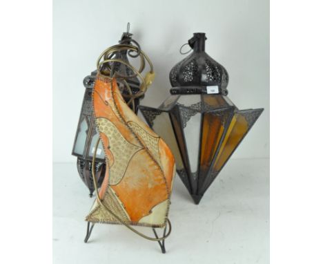 A group of three middle eastern style lamp shades and a floor lamp, two with glazed panels