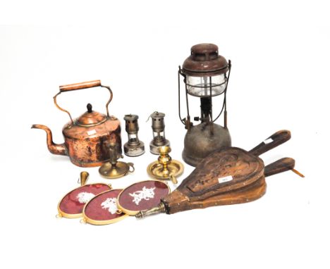 A group of vintage metalware including a copper kettle and bellows, lamps, and more