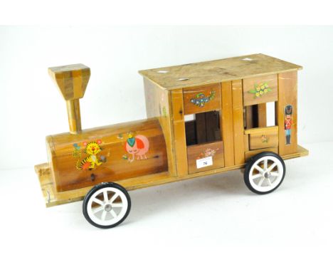 A vintage homemade wooden 'sit-on' train, with hinged doors and decorated with flowers and animals, width 63cm