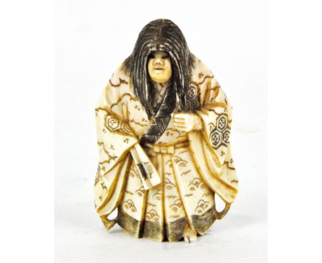 A Japanese ivory netsuke, modelled as a gentleman in traditional attire, with moving face, height 7cm