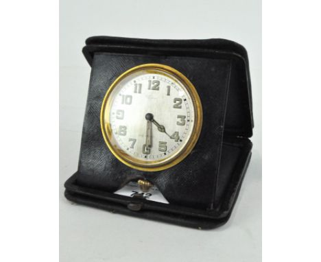 An early 20th century leather cased travelling clock, silver dial with Arabic numerals, within a black leather case, diameter