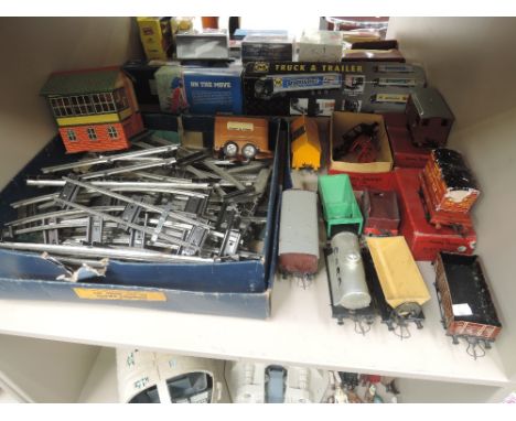 A shelf of Hornby O gauge including crane truck, flat wagon and load, milk traffic van all boxed, similar unboxed rolling sto