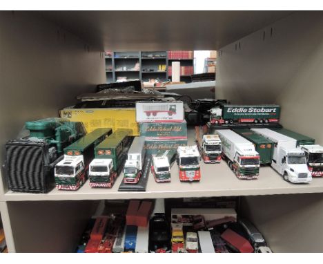 A shelf of Eddie Stobart die-cast vehicles including Corgi, Atlas etc