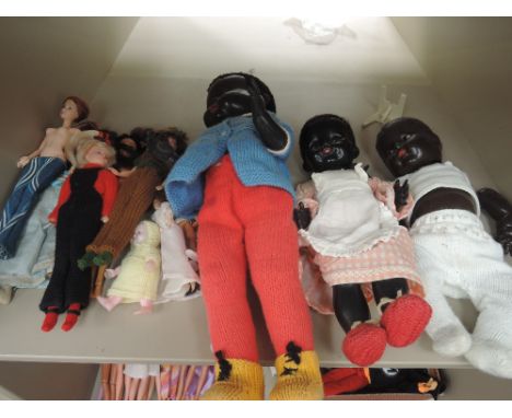 A shelf of mixed dolls including Pedigree celluloid black baby doll having walking mechanism, a Pedigree celluloid black baby