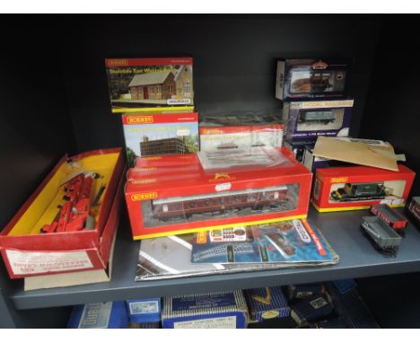 A shelf of OO gauge accessories and rolling stock including Hornby, Hornby Dublo etc, most items boxed