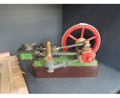 A scratch built stationary twin piston model engine having six spoke flywheel and eagle motif