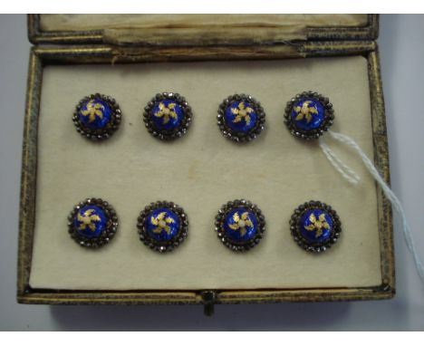 A set of eight cut steel and blue enamel buttons:, each with a mother of pearl centre in gilt foliate surrounds and with cut 