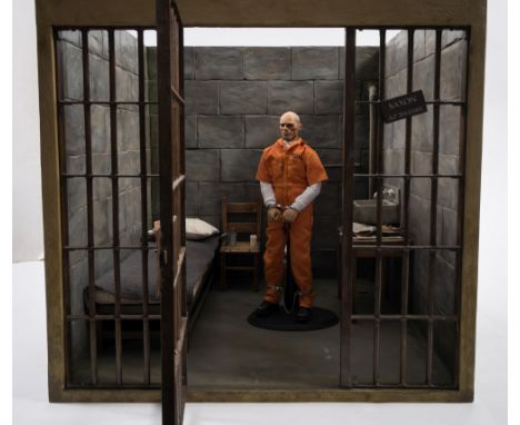 A Damtoys 1/6th scale Gangsters Kingdom figure 'Saxon':, in a scale diorama prison cell, with original box.