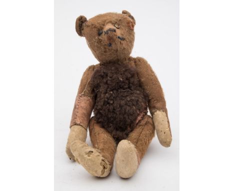 An early 20th century Steiff blonde plush bear:, with button to ear and boot button eyes, remains of stitched nose and mouth,